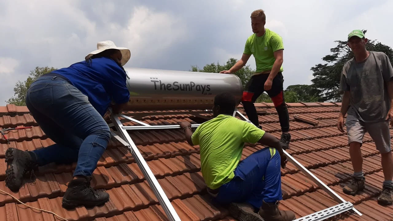 Apple Plumbing installers fitting a rooftop solar hot water system on a Sandton home